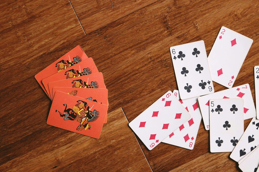 Scattered playing cards on a wooden surface, ideal for game night themes.